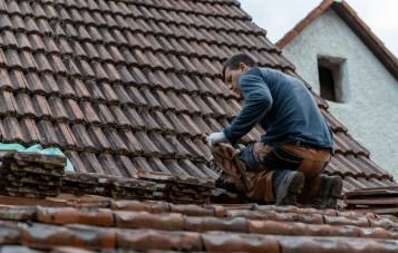 Roofer at work — replacing tiles on a Kent roof